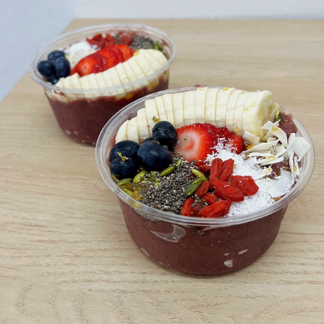 Two handcrafted açaí bowls topped with fresh fruit, chia seeds, and coconut